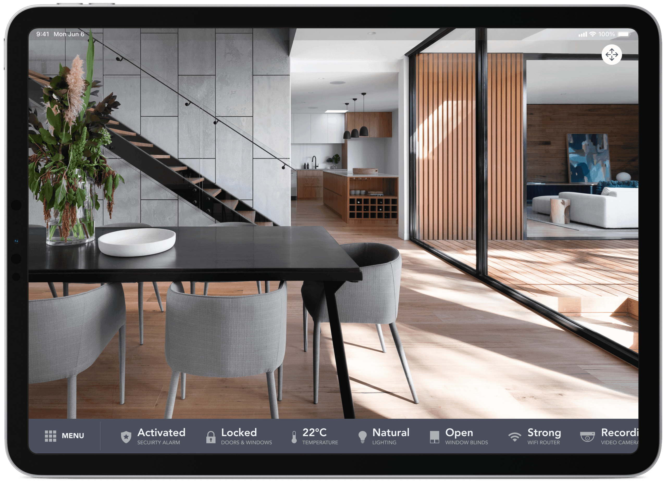 Tablet displaying a smart home monitoring dashboard overlaid on a modern interior living space photo.