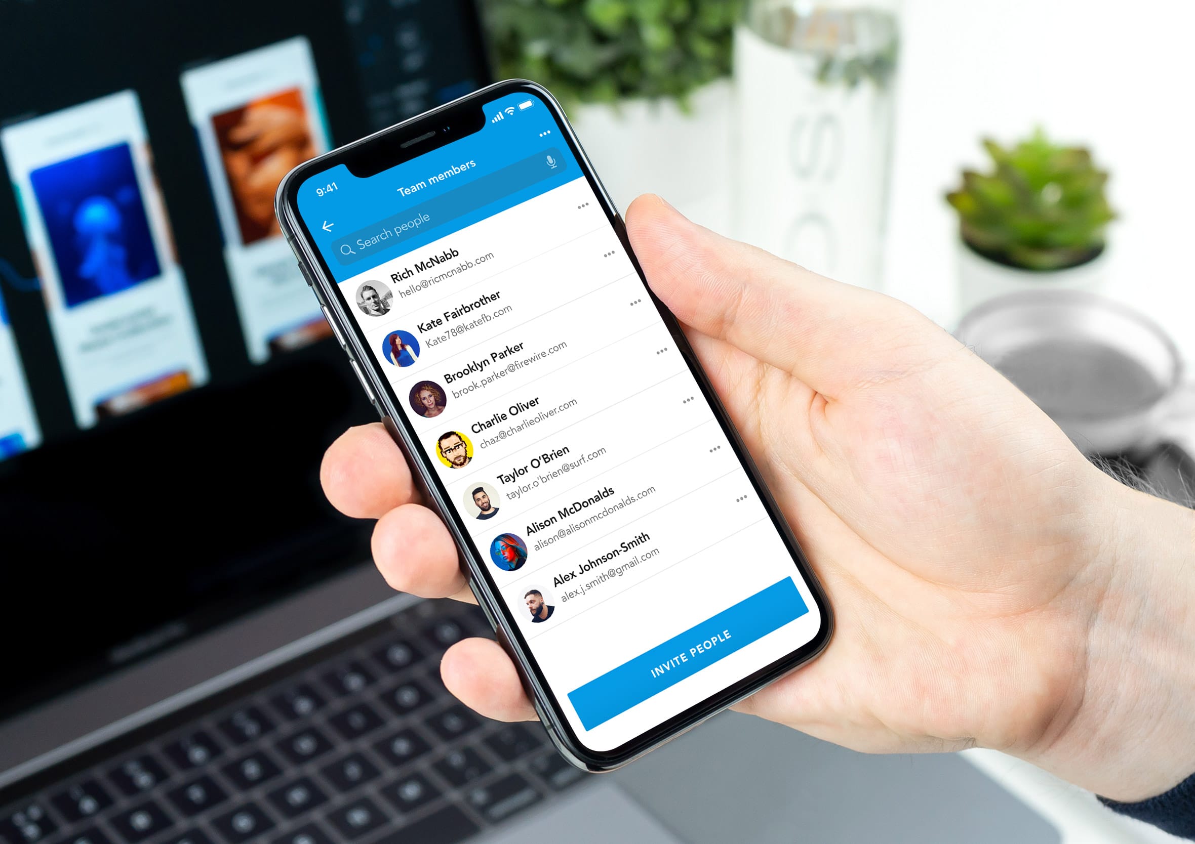 Hand holding an iPhone displaying a team members list with profile avatars, contact details, and an invite button.