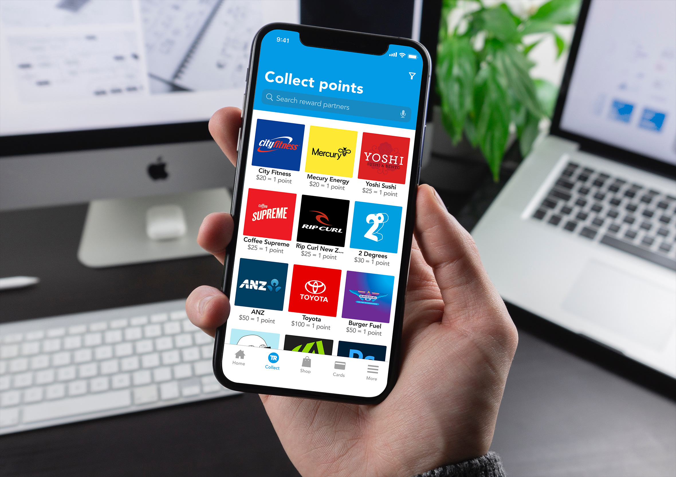 Hand holding a smartphone displaying the partner selection grid view inside an office setup.