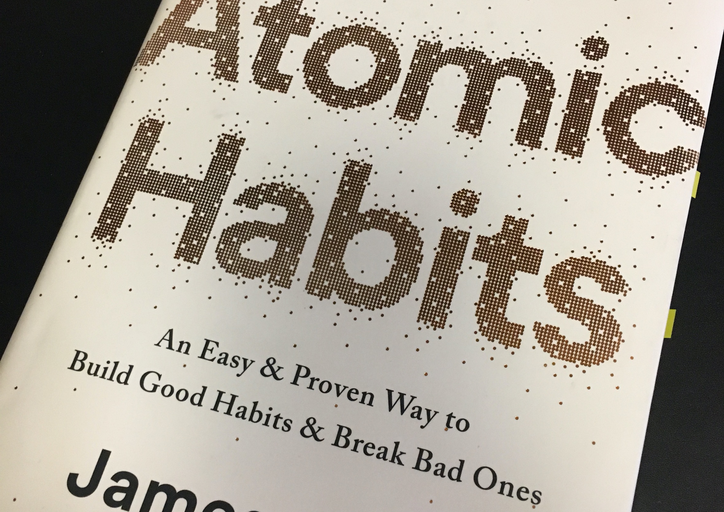 Close-up of the front cover of Atomic Habits by James Clear, showcasing halftone typography.
