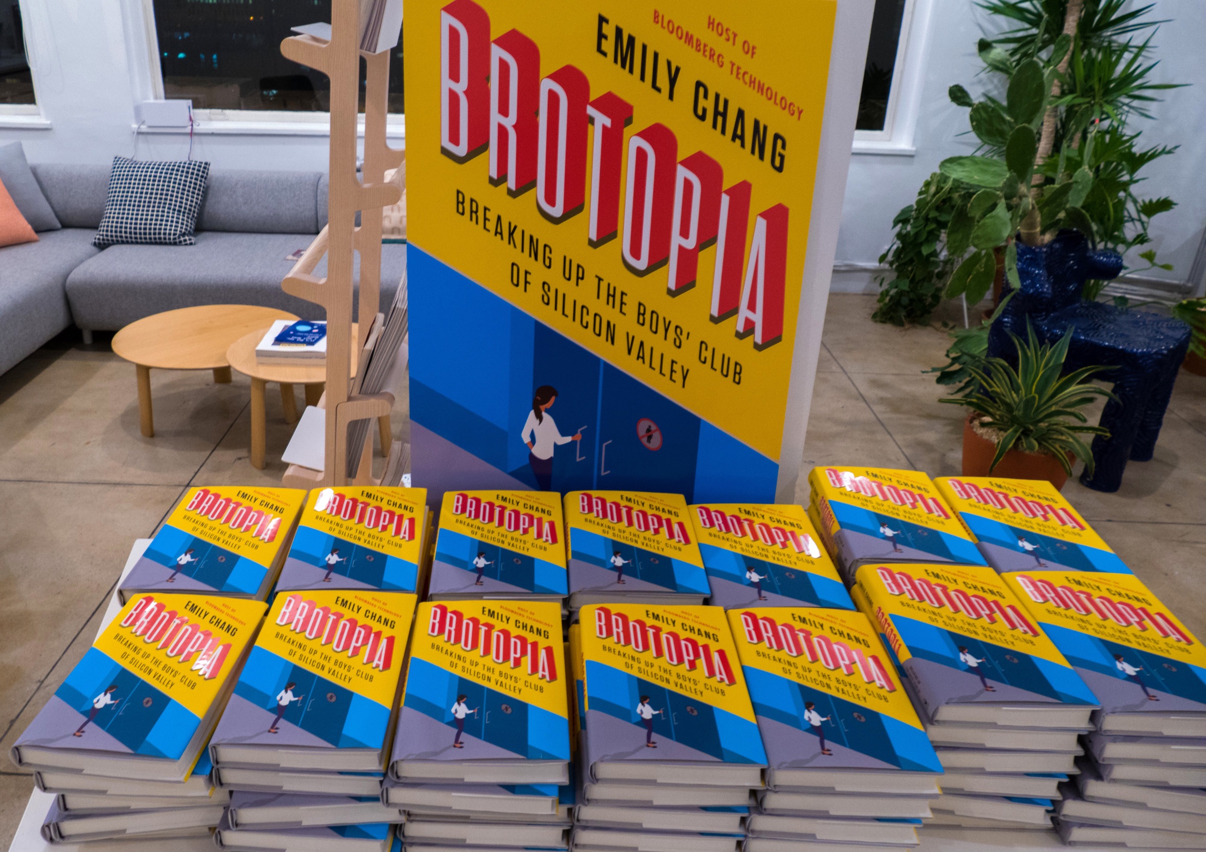 Display setup featuring stacked copies and a large promotional sign for Brotopia by Emily Chang.