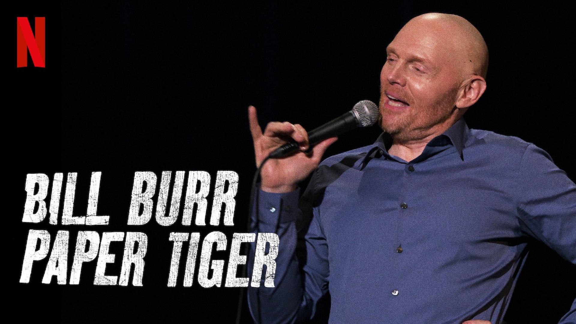 Promo graphic for Bill Burr's stand-up comedy special Paper Tiger showing Burr holding a microphone on stage against a dark background.