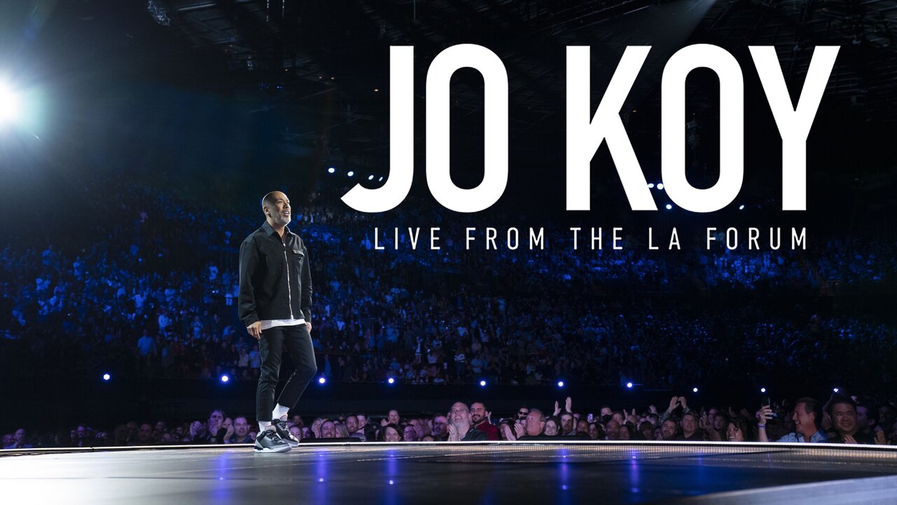 Stage banner graphic for Jo Koy's stand-up comedy special Live from the Los Angeles Forum with Koy performing under bright lights.