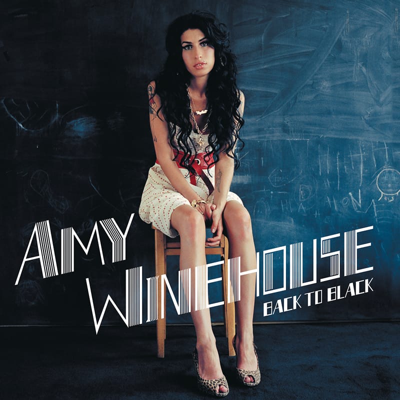 Front cover art for Back To Black by Amy Winehouse, depicting the singer sitting on the floor leaning against a white wall.