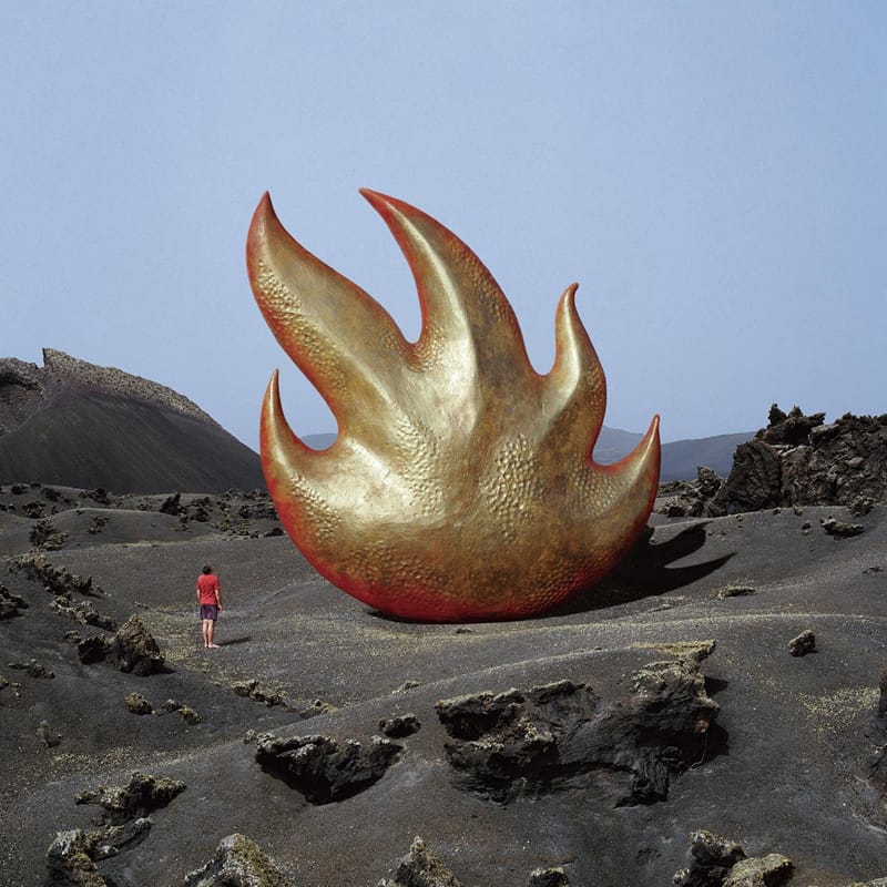 Iconic album sleeve for Audioslave's self-titled release, featuring a giant eternal flame sculpture set in a desert landscape.