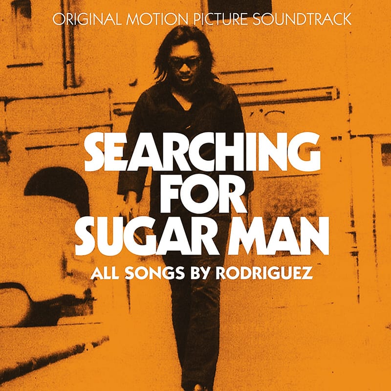 Street photograph cover for Rodriguez's Searching For Sugar Man, showing the musician walking in dark sunglasses.