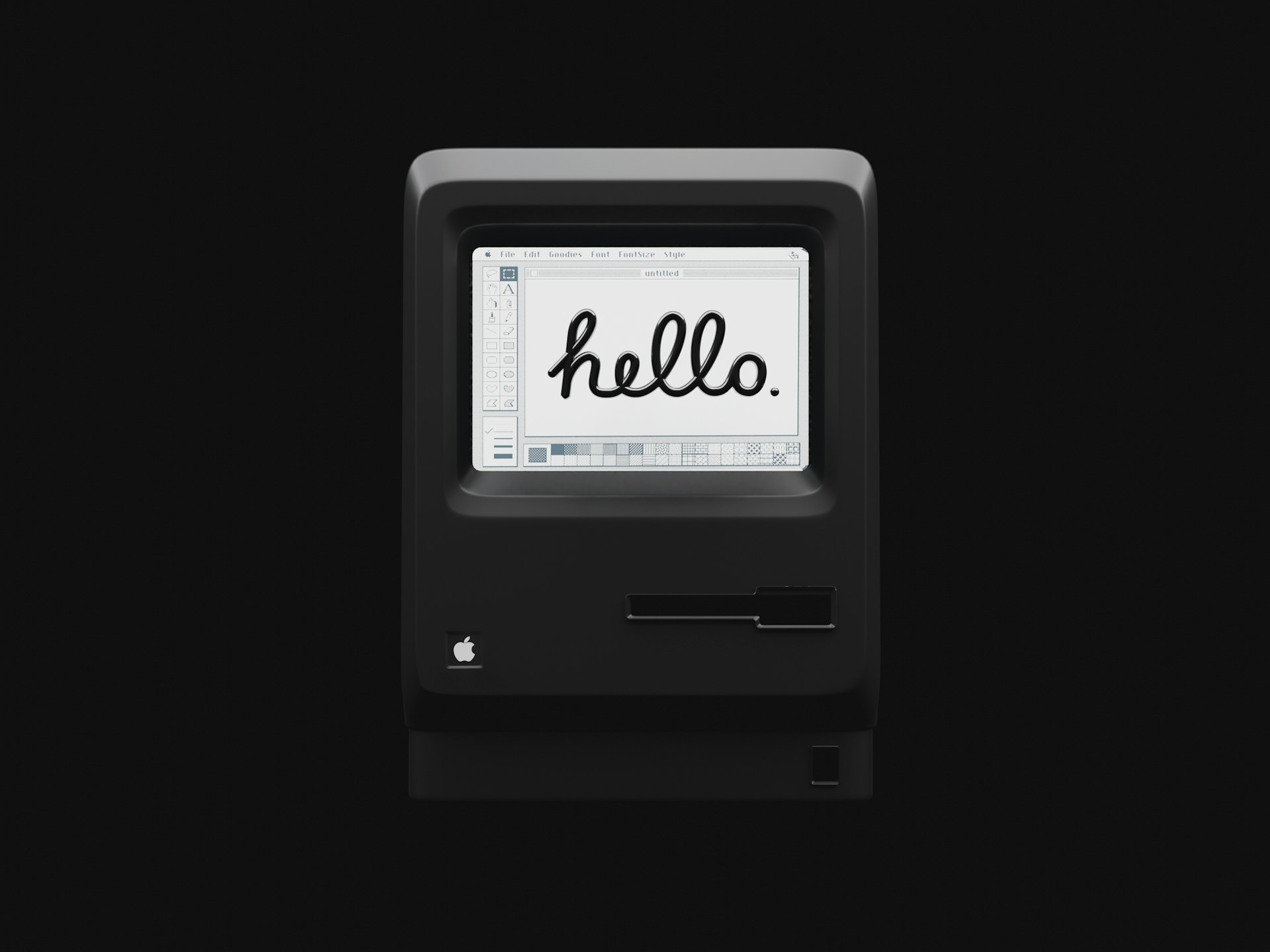 Black vintage Macintosh computer with the word hello handwritten on the white screen, set against a solid dark background.