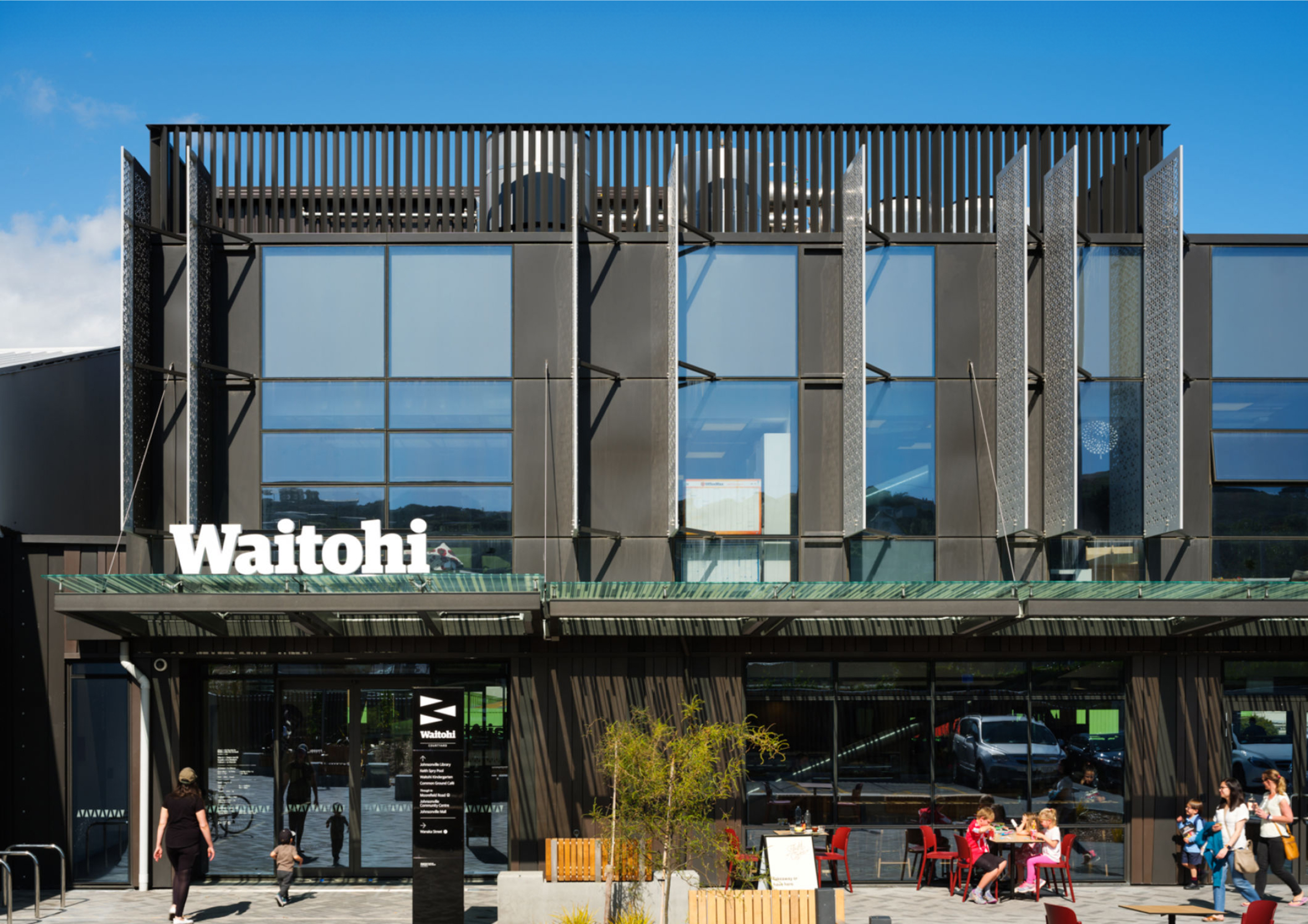Exterior of Waitohi, the Johnsonville Library and Community Hub building in Wellington, with people gathered outside