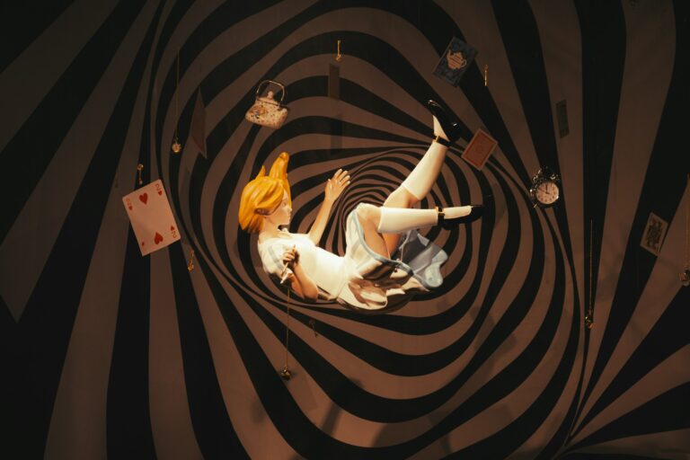 Surreal installation of a blonde figure falling through a black and white optical illusion spiral tunnel with floating playing cards and pocket watches, capturing story-driven immersive artwork.