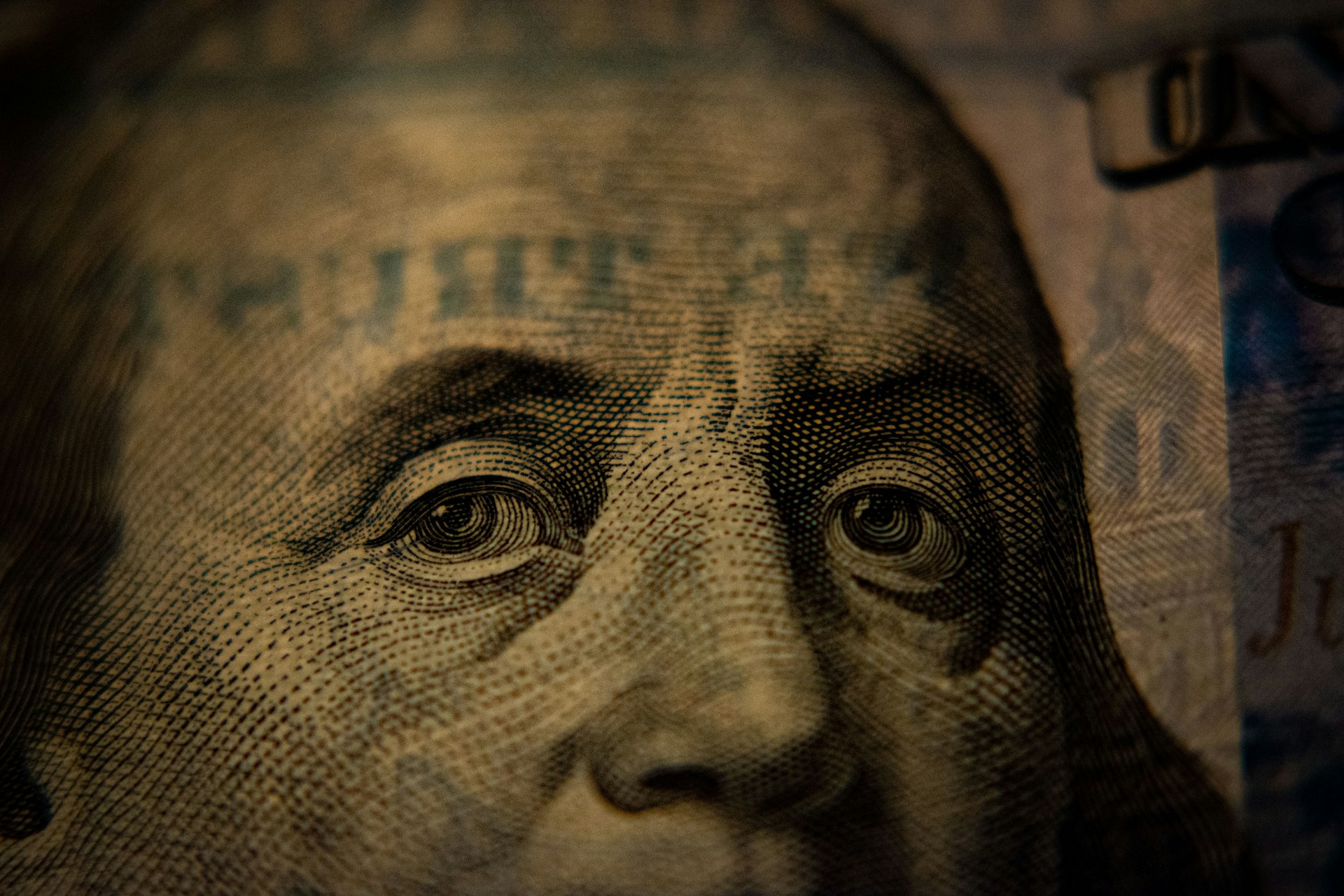 Extreme macro close-up of Benjamin Franklin's eyes on a United States 100-dollar bill.